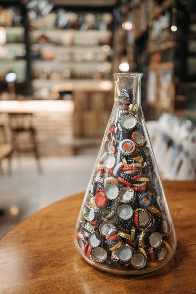 Galerie A collection of colorful beer bottle caps in a glass container in a cozy bar setting.