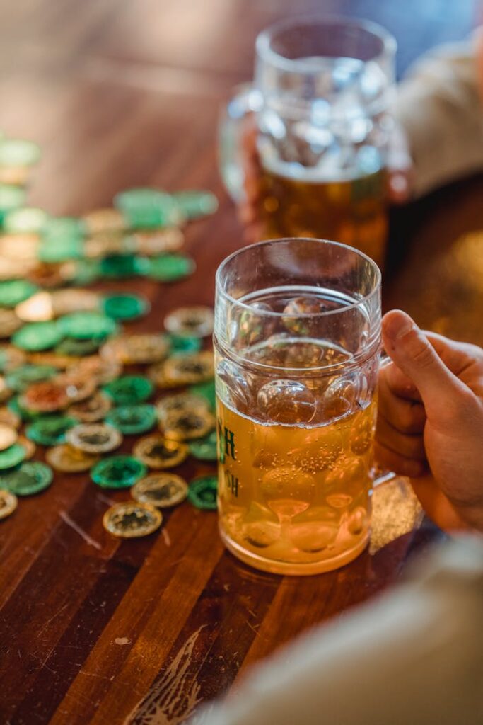 Galerie Close-up of beer mugs and game tokens on a wooden table, emphasizing leisure and fun.