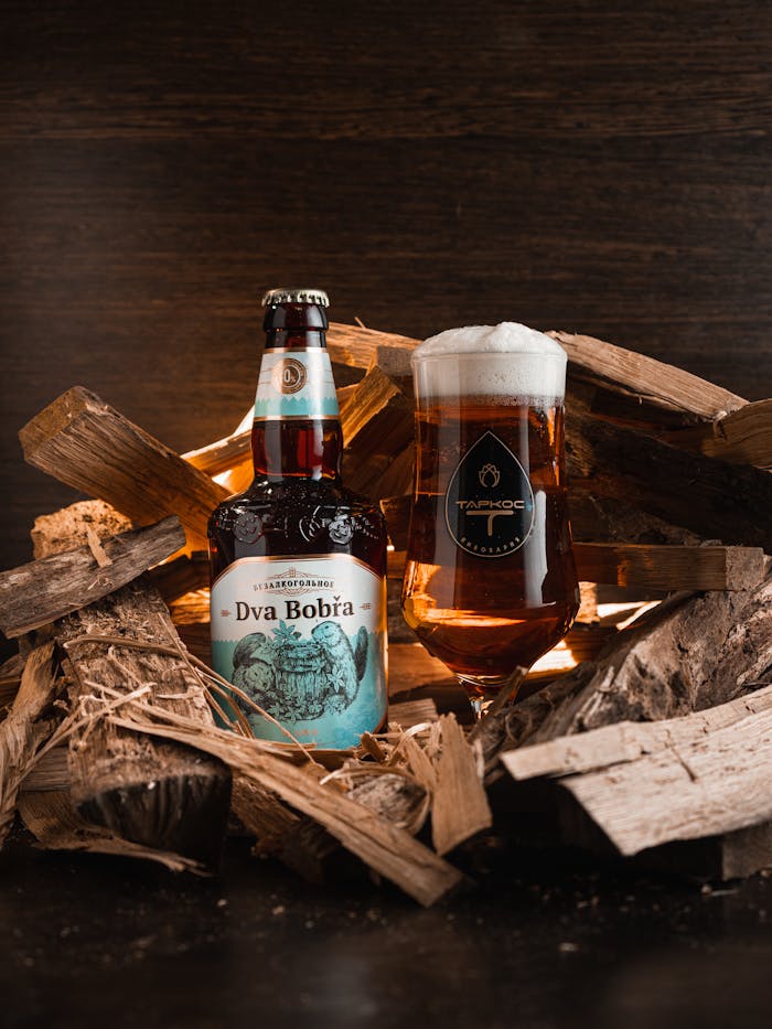 Offerings A craft beer bottle and glass on wooden logs. Perfect for bar promotions.